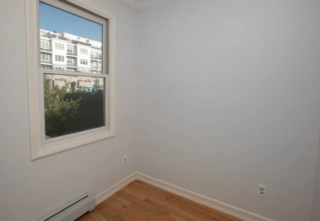 a view of a small space with wooden floor and a window