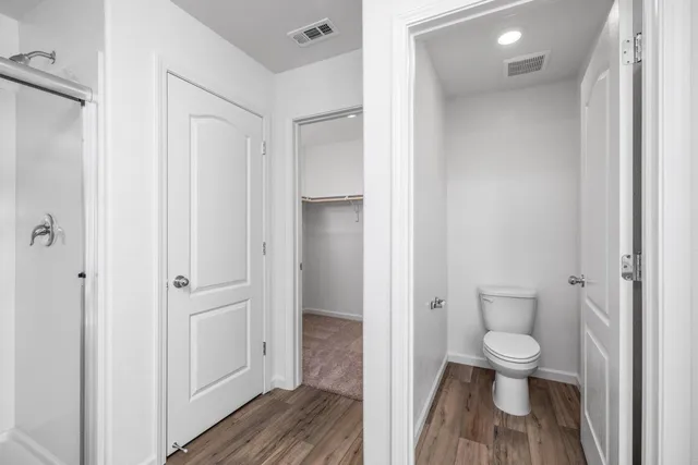 a bathroom with a granite countertop toilet a sink and a mirror