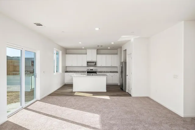 a view of kitchen with kitchen island sink and refrigerator