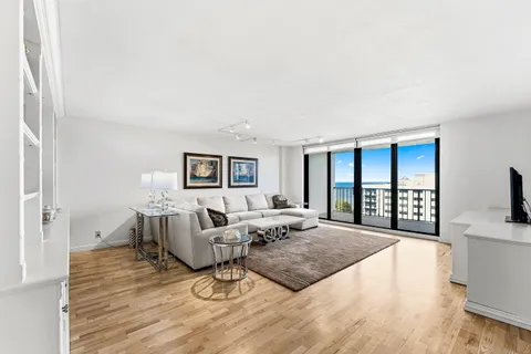 a living room with furniture a flat screen tv and a large window