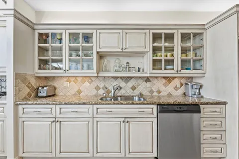 a kitchen with granite countertop cabinets and window