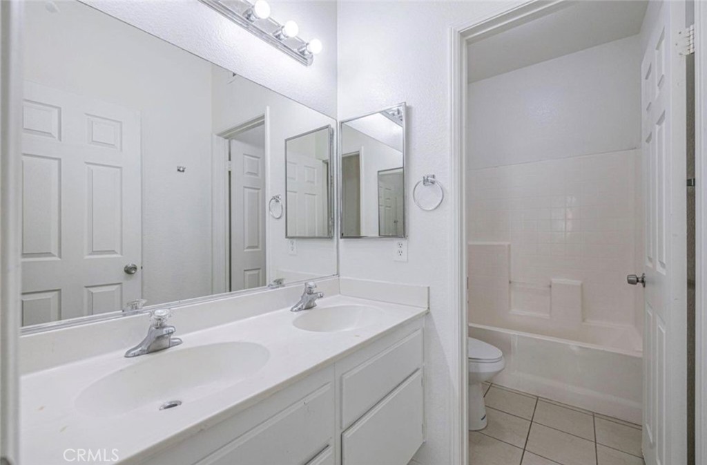 43839 58th Street West Lancaster, CA 93536 - Photo 12 of 18 a bathroom with a sink a toilet and shower