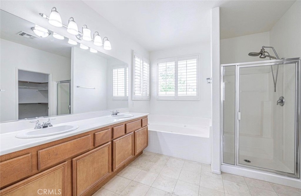 43839 58th Street West Lancaster, CA 93536 - Photo 14 of 18 a bathroom with a tub a sink and mirror