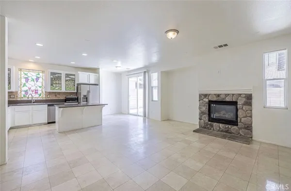 a large kitchen with granite countertop a stove a sink and a refrigerator