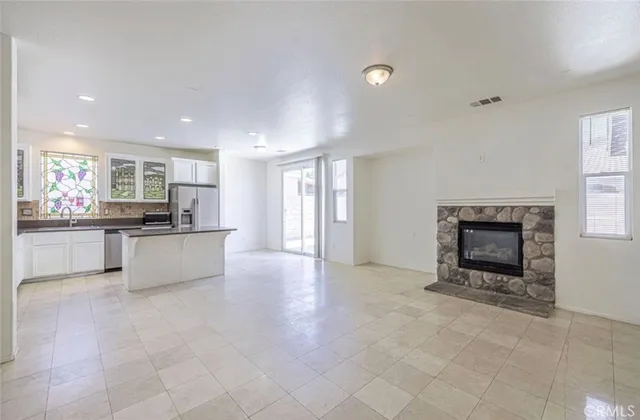 a large kitchen with granite countertop a stove a sink and a refrigerator