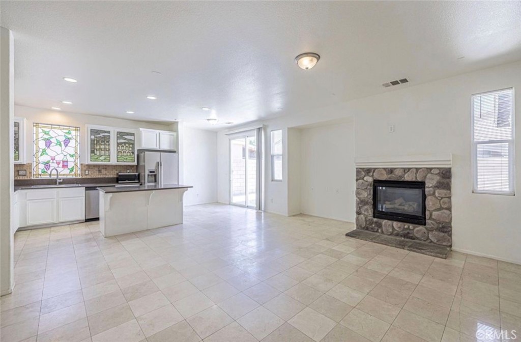 43839 58th Street West Lancaster, CA 93536 - Photo 7 of 18 a large kitchen with granite countertop a stove a sink and a refrigerator