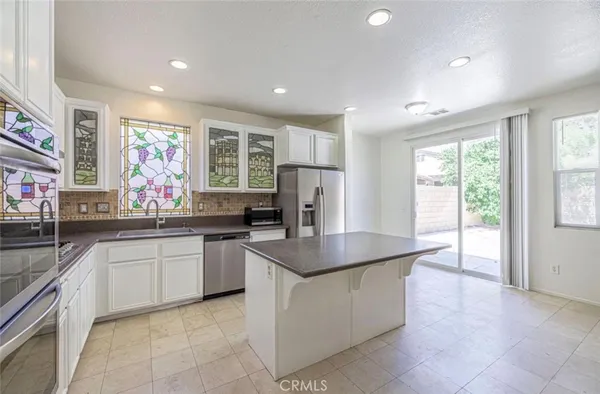 a kitchen with stainless steel appliances granite countertop a sink counter space cabinets and a large window