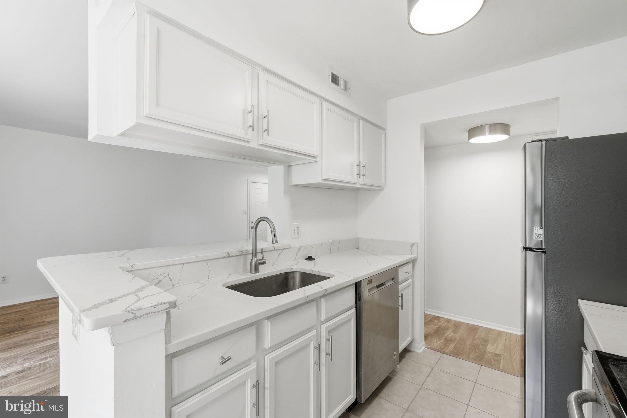 1703 Ascot Way, Unit D Reston, VA 20190 - Photo 12 of 21 a kitchen with stainless steel appliances granite countertop a sink and refrigerator