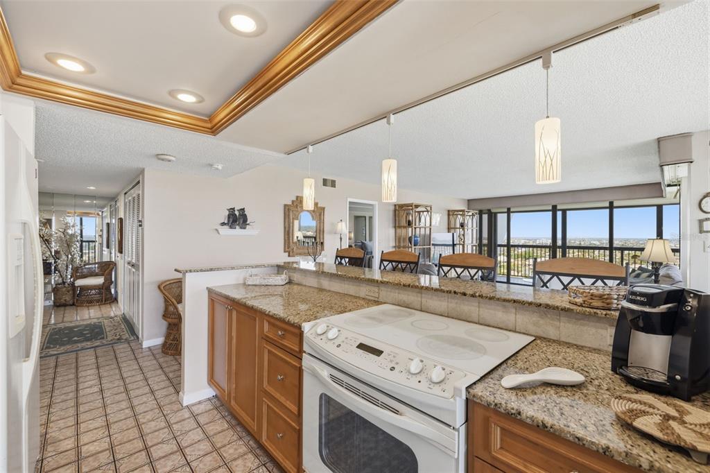 9495 Blind Pass Road, Unit 1208 St. Pete Beach, FL 33706 - Photo 11 of 61 a kitchen with a stove and a white cabinets