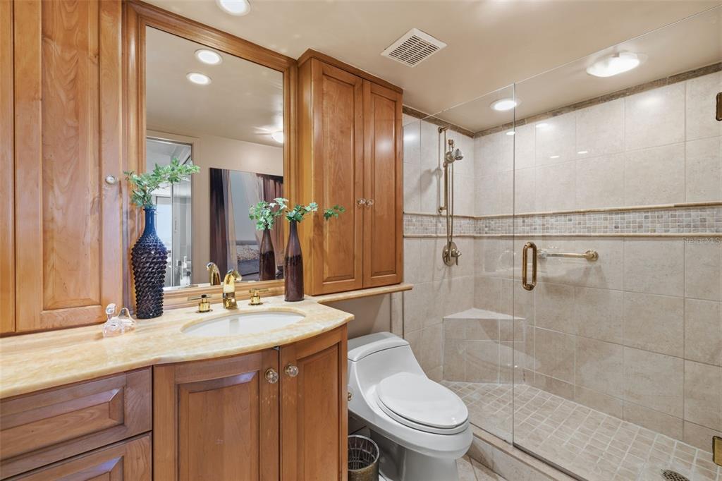 9495 Blind Pass Road, Unit 1208 St. Pete Beach, FL 33706 - Photo 16 of 61 a bathroom with a sink a toilet and shower