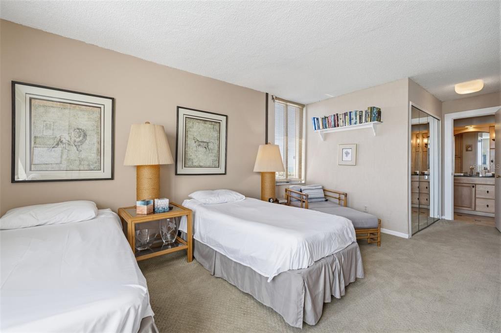 9495 Blind Pass Road, Unit 1208 St. Pete Beach, FL 33706 - Photo 20 of 61 a bedroom with a bed lamp and a window