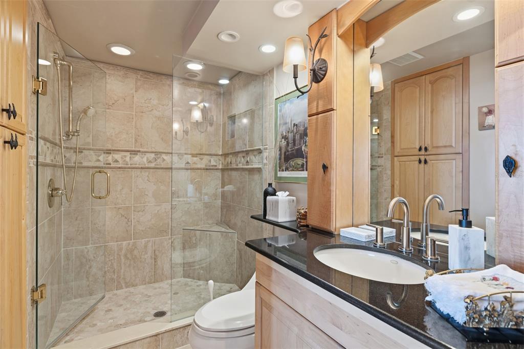 9495 Blind Pass Road, Unit 1208 St. Pete Beach, FL 33706 - Photo 21 of 61 a bathroom with a double vanity sink toilet mirror and shower