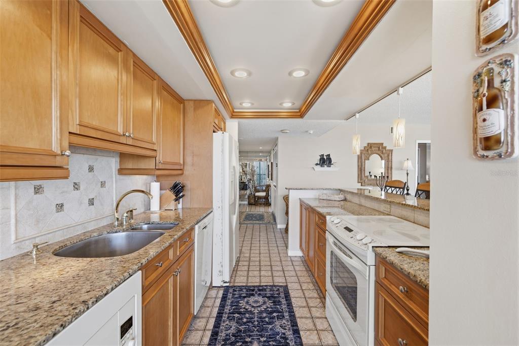 9495 Blind Pass Road, Unit 1208 St. Pete Beach, FL 33706 - Photo 27 of 61 a kitchen with a sink stove and cabinets