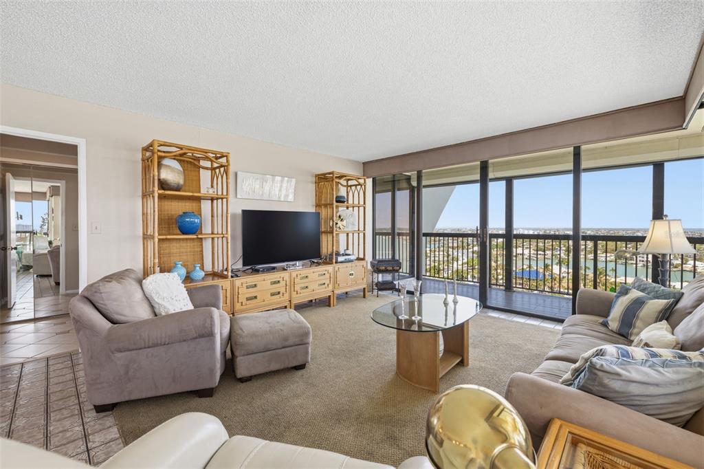 9495 Blind Pass Road, Unit 1208 St. Pete Beach, FL 33706 - Photo 5 of 61 a living room with furniture and a flat screen tv