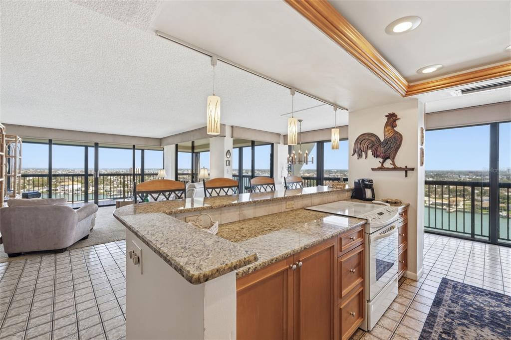 9495 Blind Pass Road, Unit 1208 St. Pete Beach, FL 33706 - Photo 9 of 61 a kitchen with granite countertop a sink and a stove