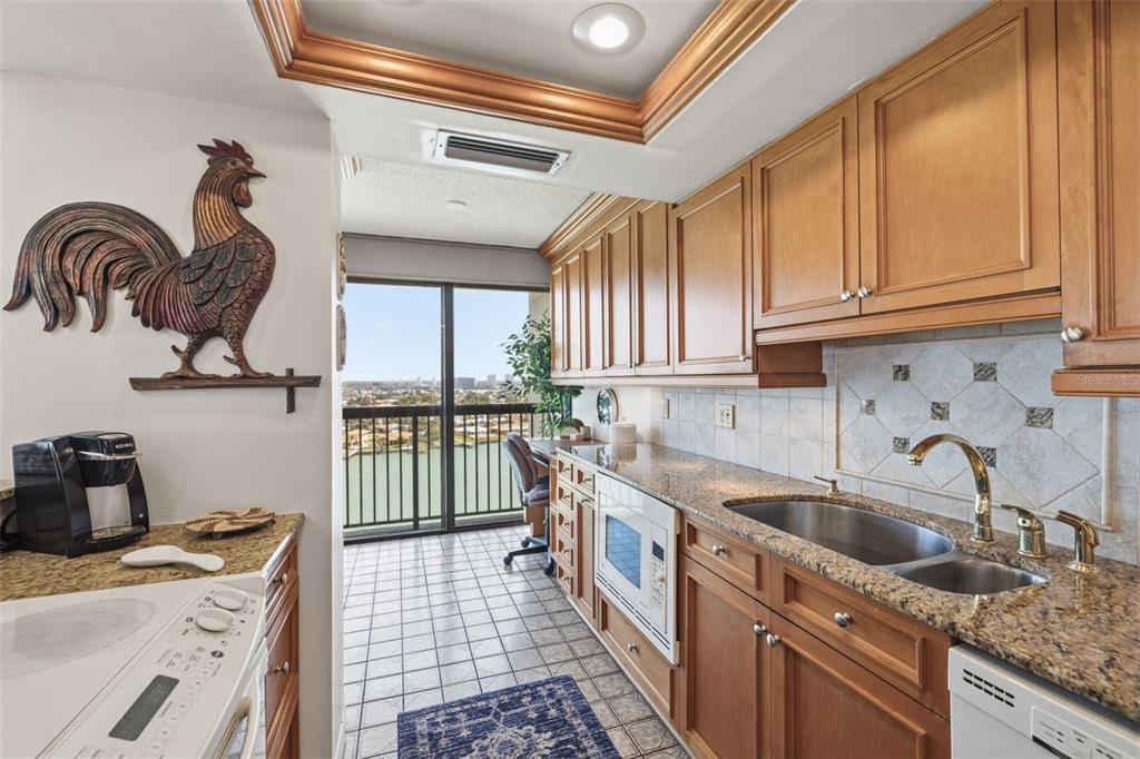 9495 Blind Pass Road, Unit 1208 St. Pete Beach, FL 33706 - Photo 10 of 61 a kitchen with a sink a stove and cabinets