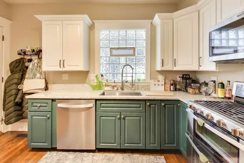 a kitchen with stainless steel appliances granite countertop a sink stove and cabinets