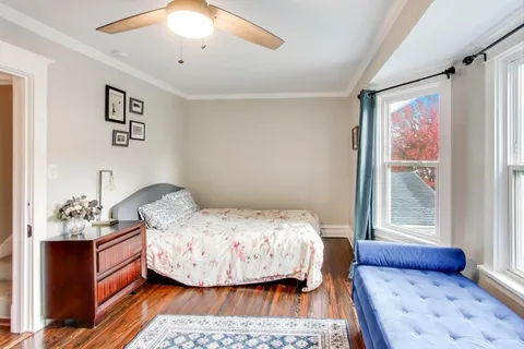 a bedroom with a bed and wooden floor