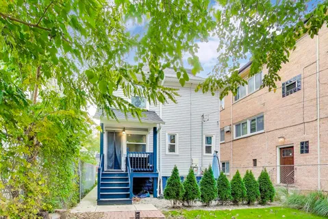 a backyard of a house with wooden floor table and chairs