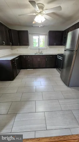 a large kitchen with kitchen island granite countertop a sink and a stove top oven