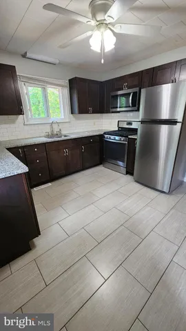 a large kitchen with a large counter top stainless steel appliances and cabinets