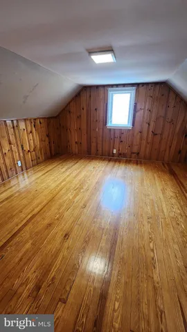 a view of an empty room with wooden floor and windows