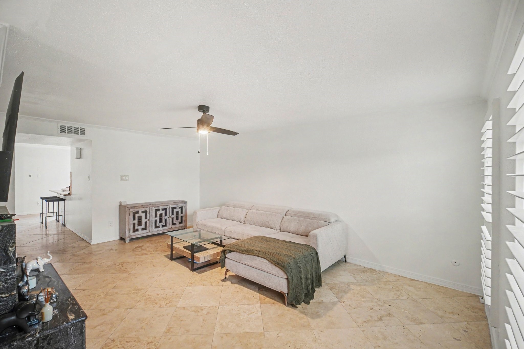 5801 Lumberdale Road, Unit 78 Houston, TX 77092 - Photo 4 of 35 Discover a bright and inviting living area featuring elegant tile flooring, a cozy sectional sofa, and modern accents, perfect for relaxation and entertaining.