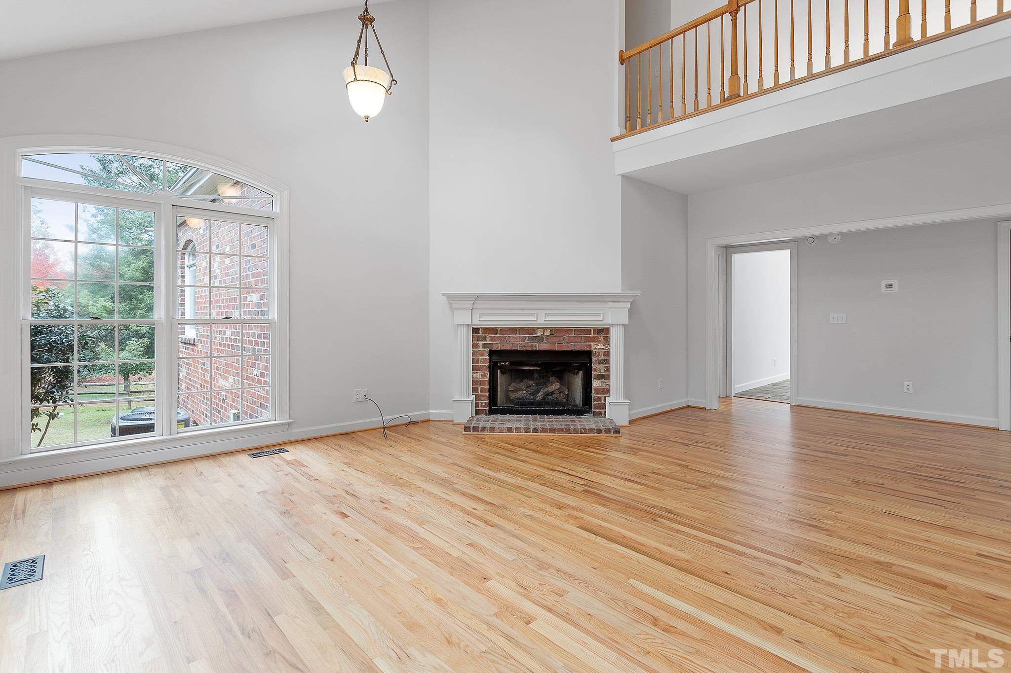 4025 Cuchalain Road Raleigh, NC 27616 - Photo 13 of 34 a view of empty room with wooden floor and fireplace