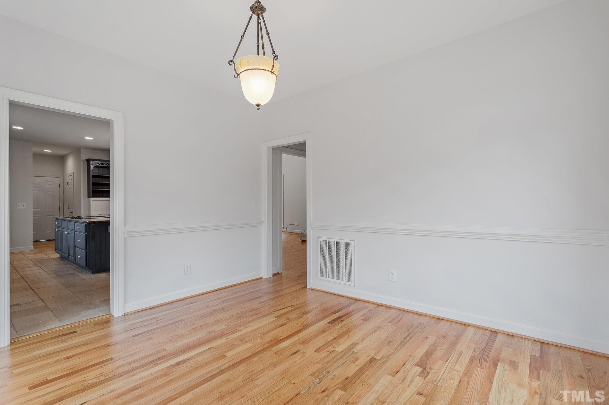 4025 Cuchalain Road Raleigh, NC 27616 - Photo 32 of 34 an empty room with wooden floor and mirror