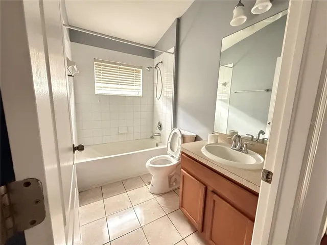 an empty room with wooden floor ceiling fan and windows