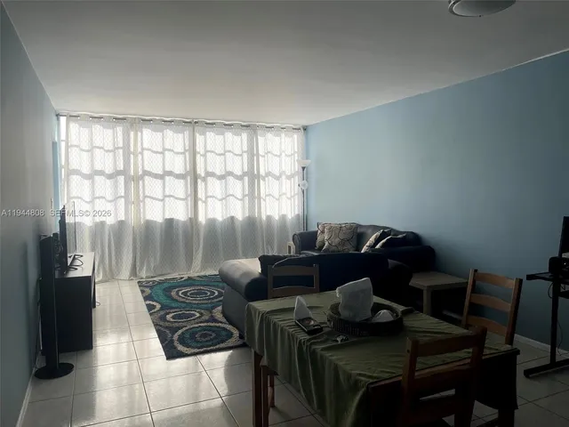 a living room with furniture and a floor to ceiling window