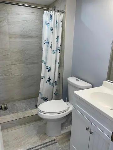 a white toilet sitting next to a bath tub
