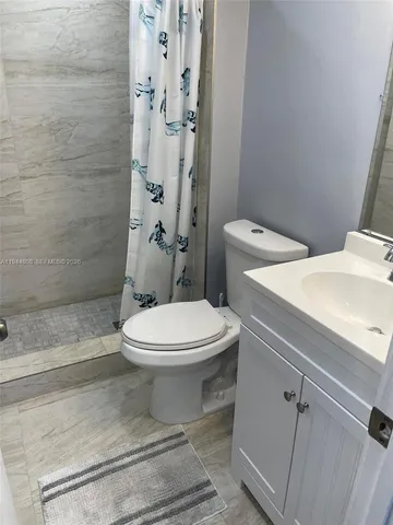 a white toilet sitting next to a bathroom sink