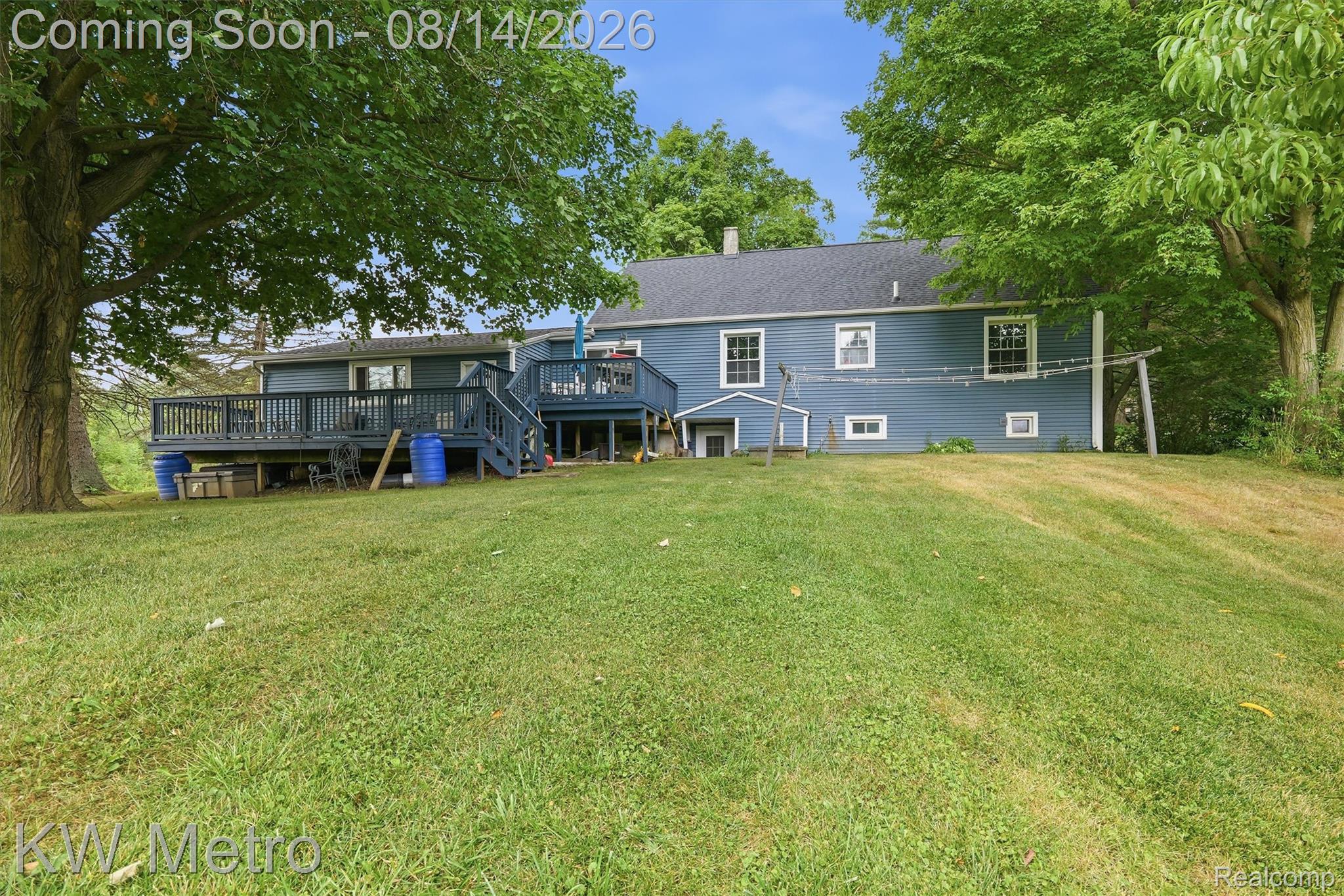 201 South Maple Leaf Road Lapeer, MI 48446 - Photo 40 of 70 Expansive backyard featuring a manicured lawn, established trees, and a multi-level deck with railing