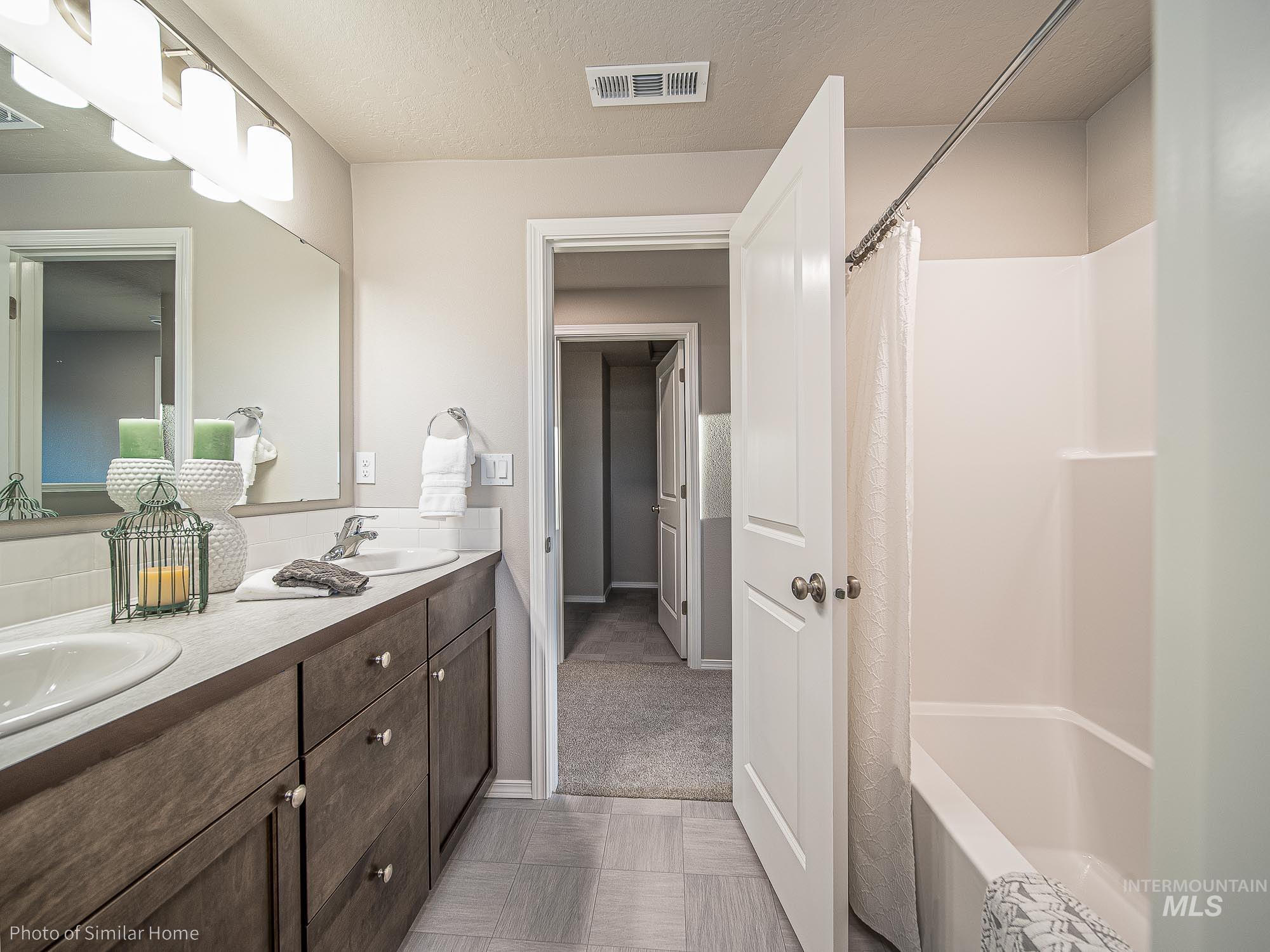 2049 Sumac Avenue Middleton, ID 83644 - Photo 6 of 6 Bathroom with double vanity, a textured ceiling, and shower / bath combo