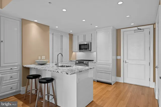 a large kitchen with stainless steel appliances granite countertop a stove a sink and a refrigerator