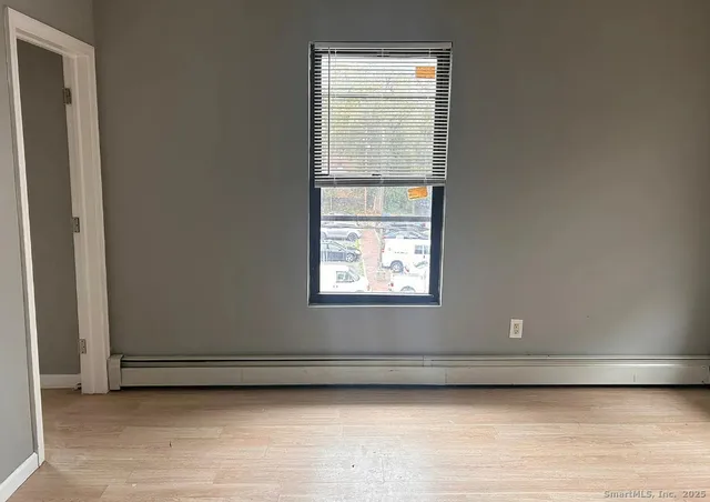 a view of a small space with wooden floor and a window