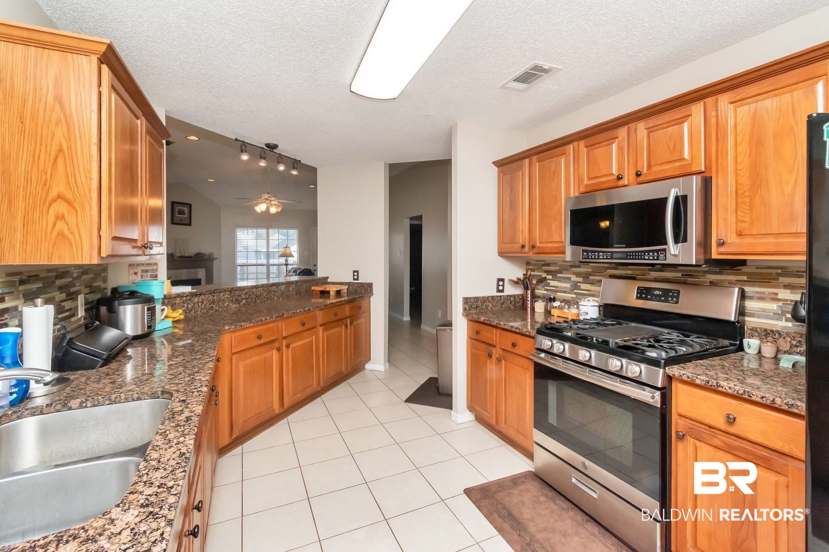 29221 Canterbury Road Daphne, AL 36526 - Photo 7 of 17 Kitchen with ceiling fan, backsplash, appliances with stainless steel finishes, and vaulted ceiling