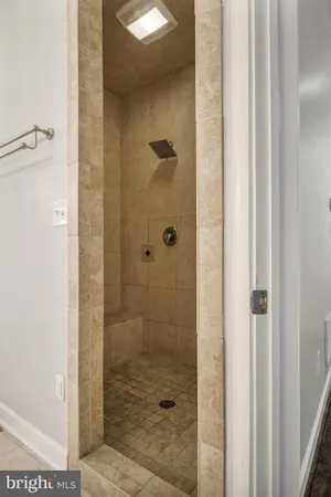 a view of an empty room with a window and a kitchen