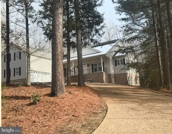 a front view of a house with a yard covered in snow