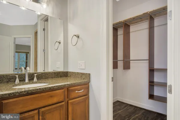 an empty room with wooden floor closet and windows