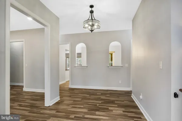 a view of a room with wooden floor and chandelier