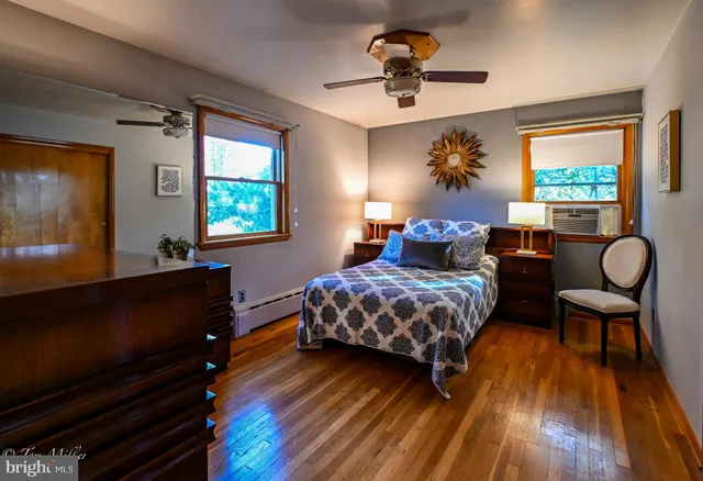 a bedroom with a large bed and a flat tv screen on dresser