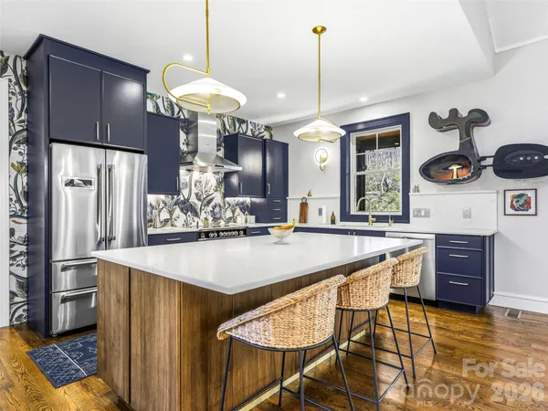 a kitchen with stainless steel appliances granite countertop a sink refrigerator and cabinets