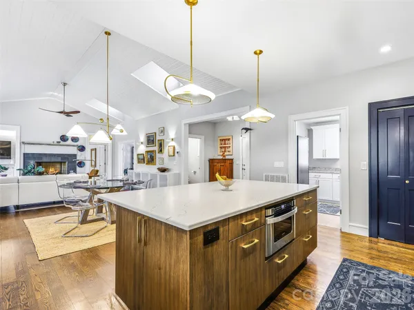 a large kitchen with kitchen island a stove a sink a center island a dining table and chairs