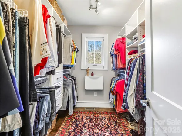 a view of walk in closet with clothes and shoes