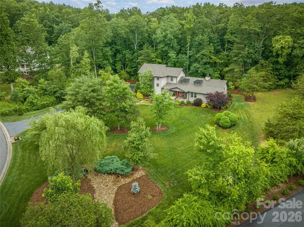 an aerial view of residential house with outdoor space and trees all around