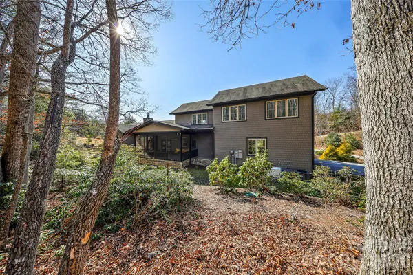 a view of a house with large trees plants and large tree