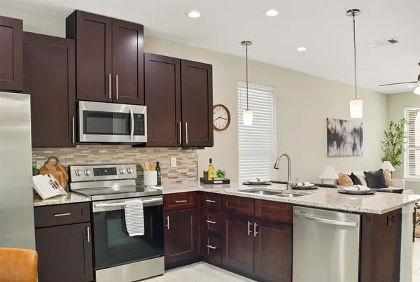 a kitchen with stainless steel appliances granite countertop a sink stove and microwave