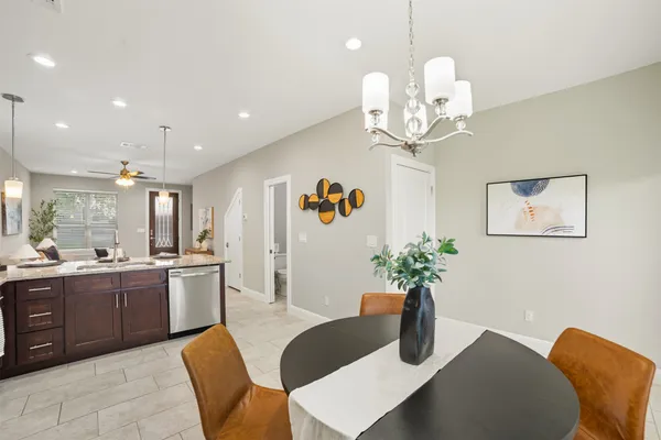 a kitchen with a dining table chairs sink and stove